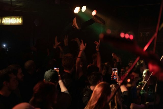 Canlı müzik etkinliği - genel konser görseli Konserde sahneye doğru ellerini kaldıran izleyiciler